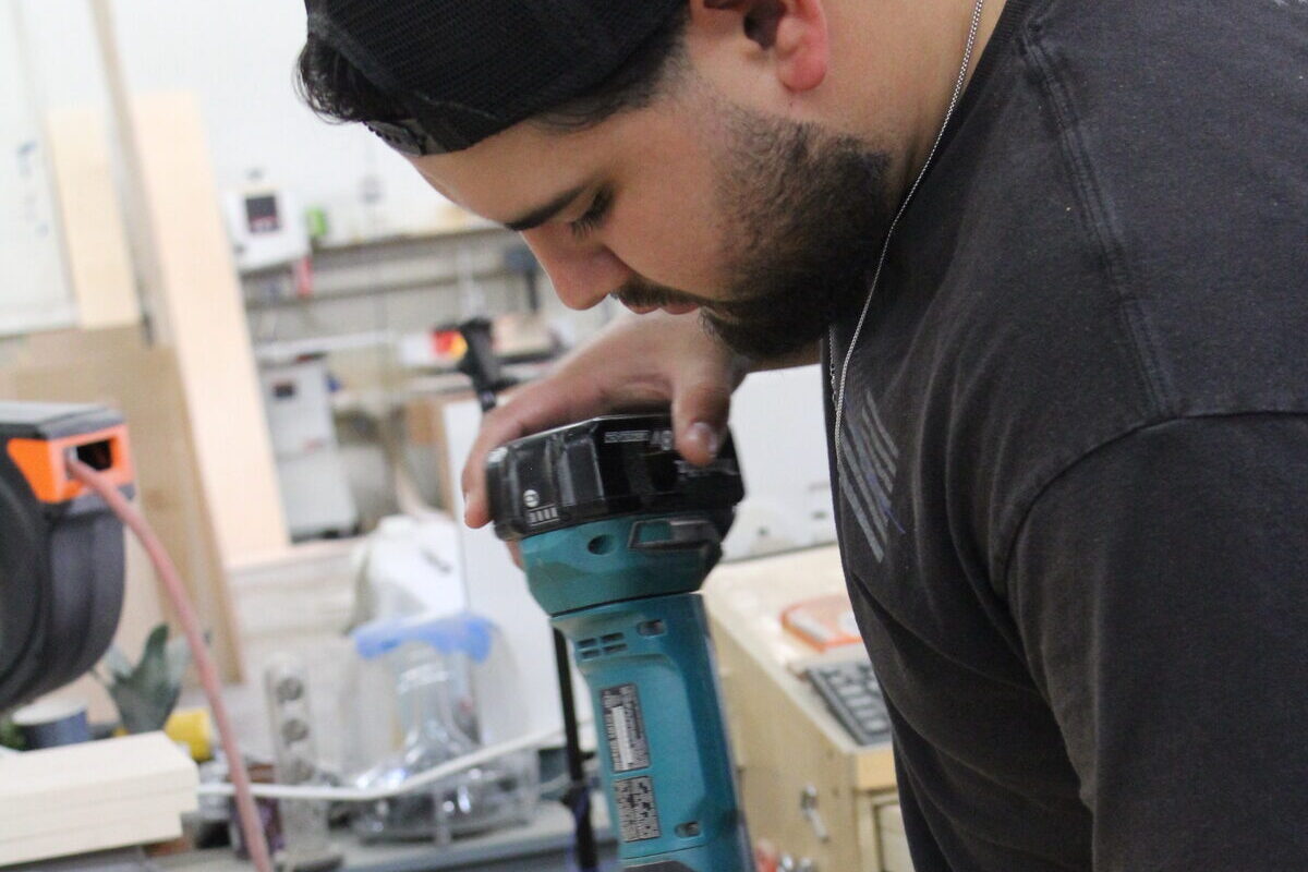 DodiHome team member hand-finishing cabinet components